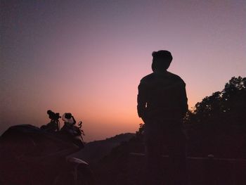 Silhouette man riding horse against sky during sunset