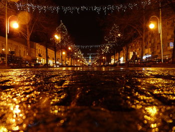 Illuminated street light against sky at night