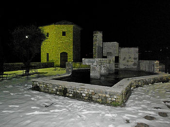 Snow covered cemetery against sky at night