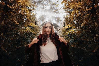 Young woman standing in park during autumn