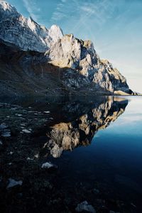 Reflection of rocks in lake against sky