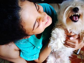 Close-up of girl playing with dog at home