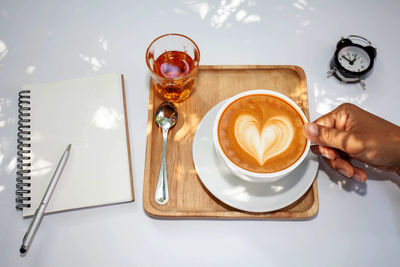 Cropped hand holding coffee on table