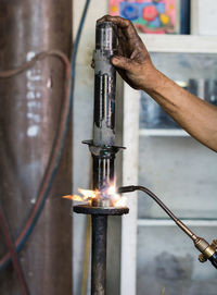 Cropped hands of welder welding metal