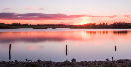 Scenic view of calm lake at sunset
