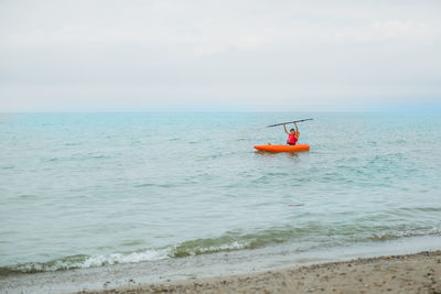 Teen boy on the lake in a kayak during summer vacation in ontario