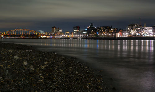 Illuminated city at waterfront at night