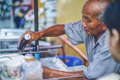 Side view of mature man making ice cream