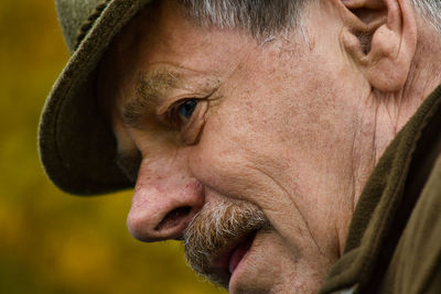 Close-up of man wearing hat looking away