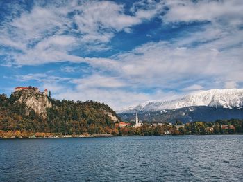 Scenic view of lake bled by mountains against sky.