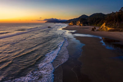 Scenic view of beach against sky during sunset