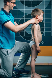 Man examining male patient in health club