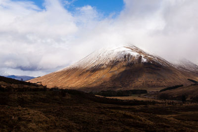 Scenic view of mountains against cloudy sky