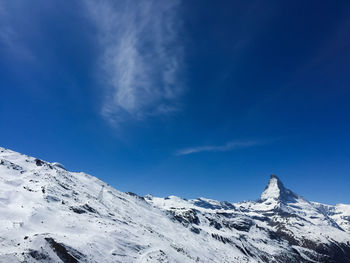 Snowcapped mountains against blue sky