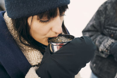 High angle view of woman drinking coffee while standing with friend