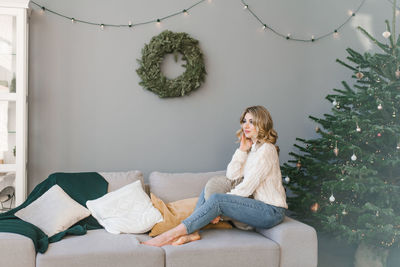 Happy young woman celebrates christmas alone and is happy alone with herself