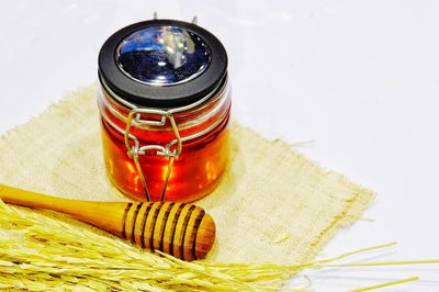 High angle view of honey with wheat on white background