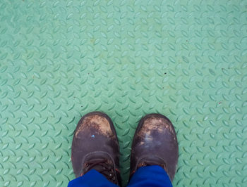 Low section of person wearing shoes standing by swimming pool