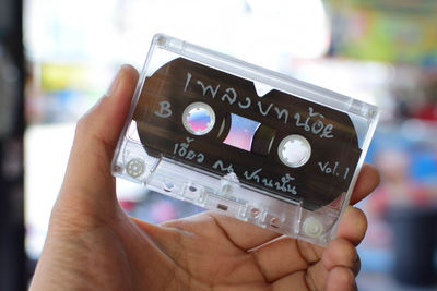 Close-up of person hand holding audio cassette