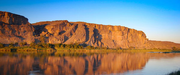 Scenic view of lake and mountains against clear sky