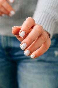 Manicured female hands with stylish blue nails and minimalistic design. trendy modern design manicur