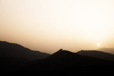 Scenic view of mountains against clear sky during sunset