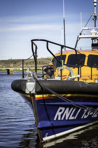 Boats moored at pier against blue sky