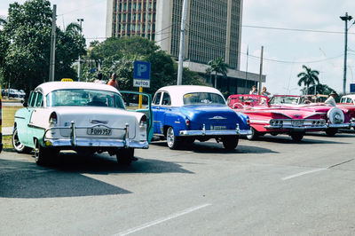 Cars on city street by buildings