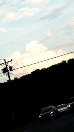 Power lines against cloudy sky