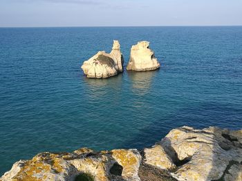 Scenic view of rock formation in sea against sky