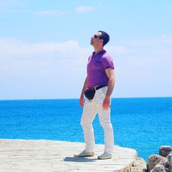 Full length of man standing in sea against sky