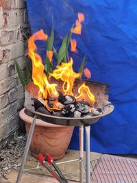 Close-up of fire on barbecue against wall