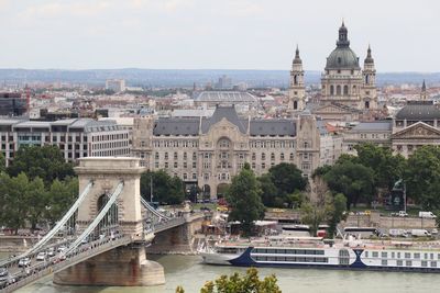 Arch bridge over river against buildings in city