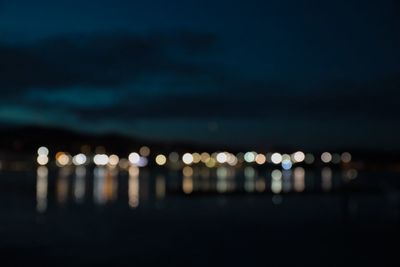 Defocused image of illuminated lights in city at night