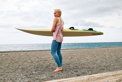 Full length of young woman exercising on beach