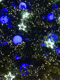 Low angle view of illuminated lights against sky at night