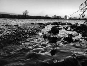 Surface level of rocks in sea against sky