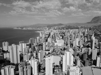 Aerial view of buildings in city against sky