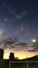 Low angle view of illuminated street light against cloudy sky