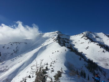 Panoramic view of snowcapped mountain against blue sky