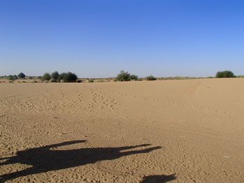 Scenic view of desert against clear blue sky