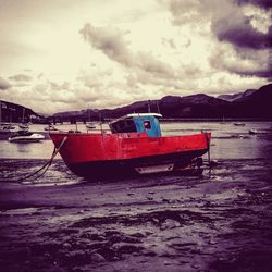 Boats in sea against cloudy sky