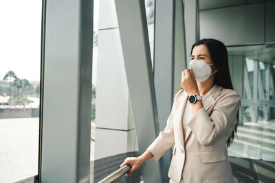 Full length of woman standing by window