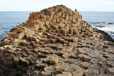 Stone wall by sea against sky