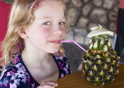 Portrait of cute girl having drink at table