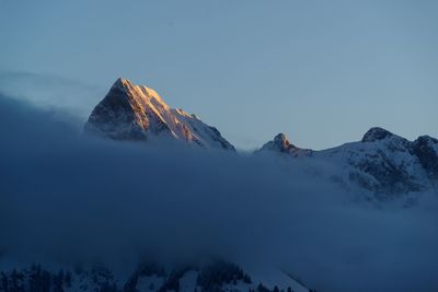 Scenic view of snowcapped mountains against clear blue sky