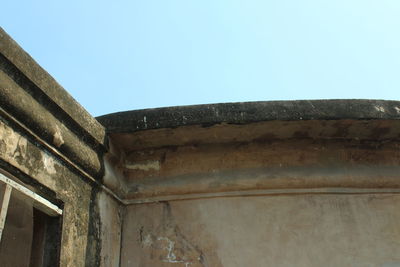 Low angle view of old building against clear blue sky