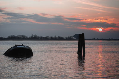 Sailboat in sea against sky during sunset