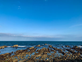 Scenic view of sea against blue sky