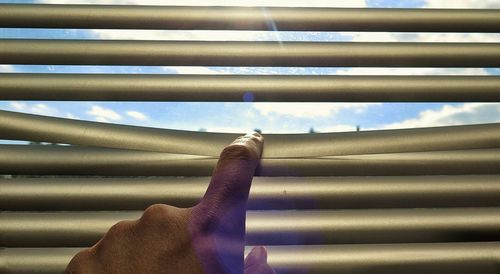 Close-up of hand against sky